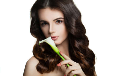 Young Brunette Woman on White. Healthy Skin, Perfect Hairstyle and Flowerの写真素材