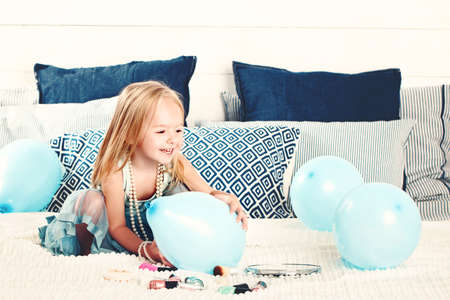 Cute Child Girl Having Fun with Blue Balloons at Home. Small Girl, 2 yearsの写真素材