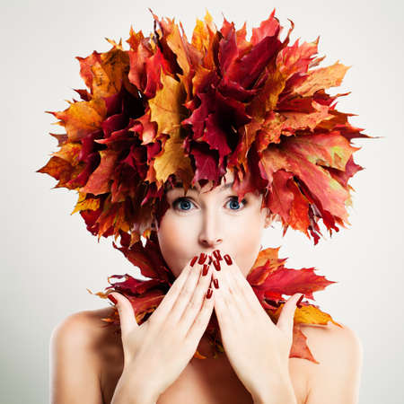 Surprised Woman with Autumn Leaves. Surprise and Funの写真素材