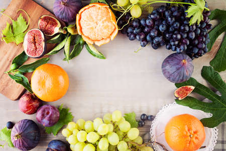 Food Background Border with Colorful Fruit. Grape, Orange, Figs and Plum. Healthy Foodの写真素材