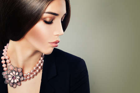 Young Woman Fashion Model with Makeup and Jewelry Necklace on Banner Backgroundの写真素材