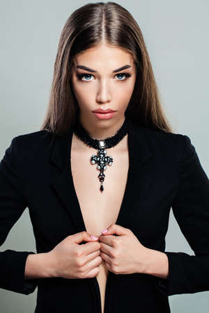 Sexy Fashion Model in Black Suit. Beautiful Young Woman with Makeup, Long Hair and Jewelryの写真素材