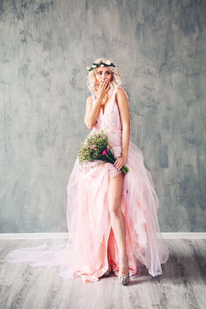 Happy Blonde Beauty. Nice Model Woman in Pink Dress on Grey Backgroundの写真素材