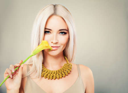 Gorgeous Woman with Blonde Hair. Makeup, Flower and Blonde Hairstyleの写真素材