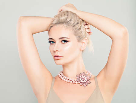 Beautiful Glamorous Blonde Woman Fashion Model with Pink Flower Necklaces and Blonde Hairstyleの写真素材