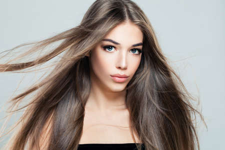 Beautiful Girl with Blowing Hair. Young Woman Fashion Model with Long Healthy Hairstyle, Beauty Salon Backgroundの写真素材