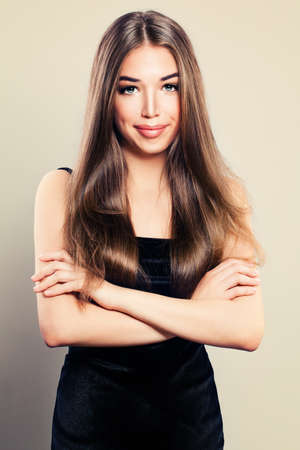Young Cute Woman in Black Dress. Smiling Girl with Crossed Armsの写真素材