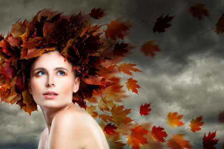 Fantasy Autumn Season Concept. Autumn Model Woman against Cloudy Skyの写真素材