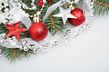 Christmas Decor on White Background. Xmas Tree Twig, Red Stars, Glitter Glass Ball, Silver Garland and Ribbonの写真素材