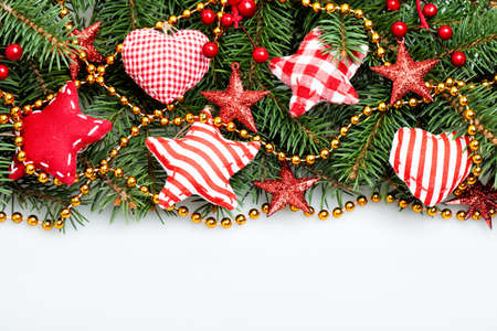 Christmas Decorations Border on White Background. Xmas Tree Twig, Red Stars and Gold Garlandの写真素材