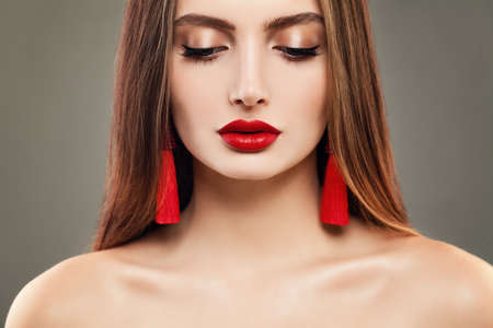 Young Woman with Red Lips Makeup and Jewelry Earrings. Beautiful Model, Cute Faceの写真素材
