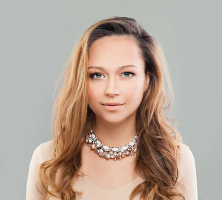 Perfect Fashion Model Woman with Wavy Hairstyle and Jewelry on Grey Backgroundの写真素材