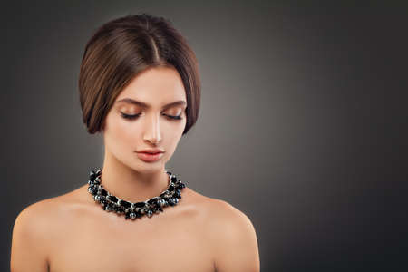 Beautiful Young Woman Fashion Model with Pearls Necklaces and Makeup on Dark Backgroundの写真素材