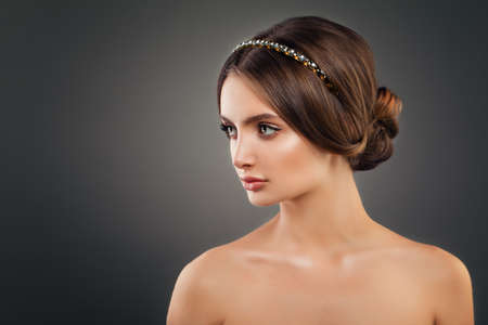 Beautiful Young Woman Fashion Model with Wedding Hairstyle, Makeup and Golden Hair Decorの写真素材