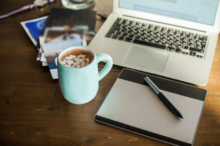 Workplace Concept. Wooden Deck with Graphic Tablet, Laptop and Coffee Cupの写真素材