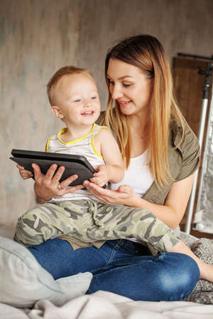 Happy mother with her son smiling and using digital tablet.の写真素材