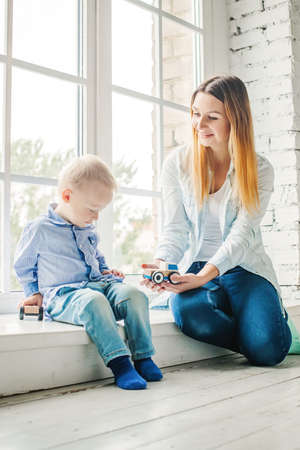 Young Woman and Little Child Boy with Wooden Toys at Homeの写真素材