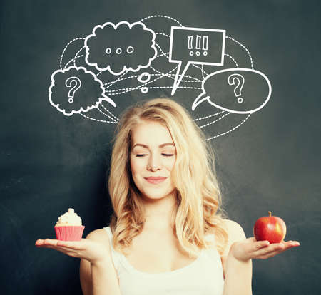 Diet and Overweight Concept. Cute Woman with Healthy and Unhealthy Foodの写真素材
