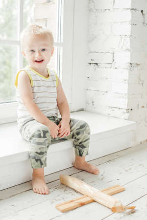 Happy child boy having fun with wooden plane toy at homeの写真素材