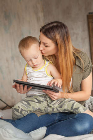 Funny mom and child are having fun with tablet.の写真素材