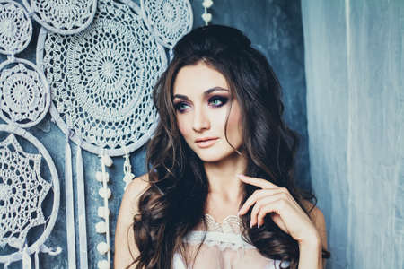 Female Model Face. Cute Young Woman with Long Curly Wedding Hairstyle and Bridal Makeup.の写真素材