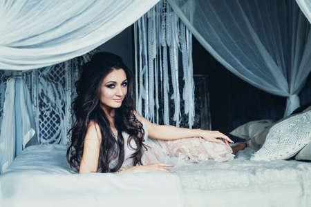 Fashion Photo of Young Beautiful Caucasian Brunette in White Retro Backgroundの写真素材