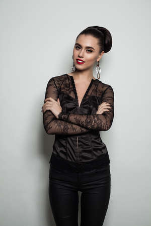 Smiling Woman against Gray Wall Background. Female Model in Black Clothesの写真素材