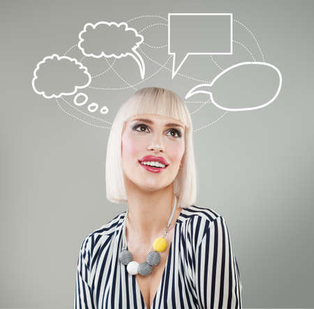 Thinking woman with many ideas in empty bubble on grey background with her finger at her faceの写真素材
