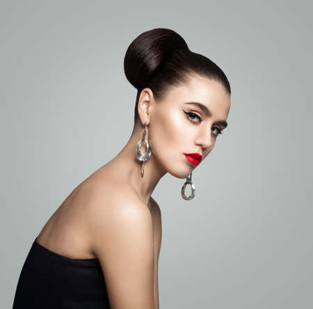 Fashion Portrait of Young Woman with Retro Styling Hair Bun Hairstyle and Eyeliner Makeupの写真素材