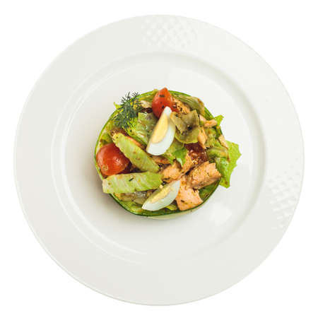 Smoked salmon salad isolated on white background. Salmon, eggs, lettuce and tomatoes on white plate, top viewの写真素材