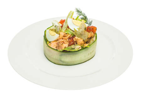 Salmon salad on white plate isolated. Salmon, eggs, lettuce and tomatoes. Gourmet restaurant foodの写真素材