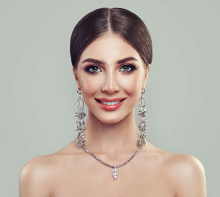 Young Perfect Woman with Jewelry Necklace and Silver Earrings. Smiling Model Girlの写真素材