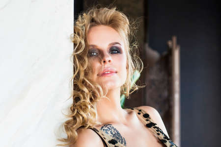Sexy Blonde Woman Portrait. Female Model with Long Wavy Hair on Background with Copy spaceの写真素材