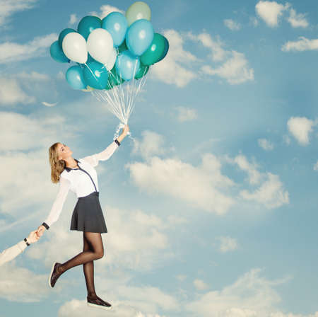 Young Woman with Balloons against Blue Cloudy Sky, Vintage Holiday Backgroundの写真素材