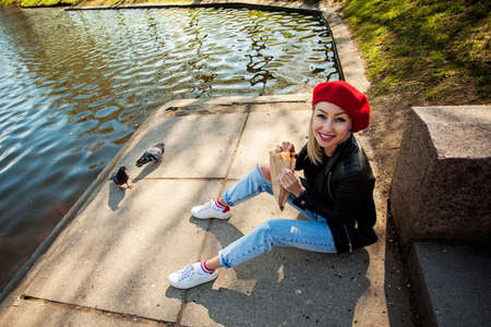 Smiling woman fashion model in french beret hat in park outdoorsの写真素材