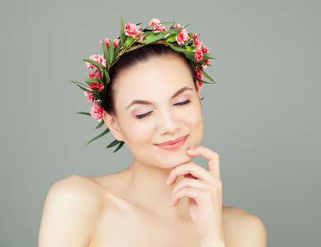 Spa Woman with Healthy Skin and Cute Smile Thinking. Pretty Girl with Flowers and Green Leavesの写真素材