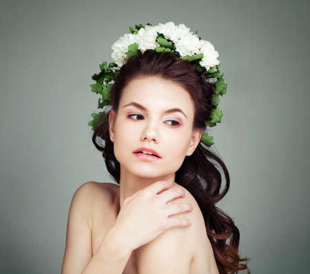 Young Female Model with White Flowers and Green Leaves on Hairの写真素材