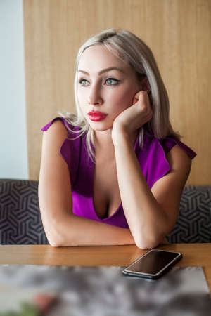 Cute blonde woman dreaming in cafeの写真素材
