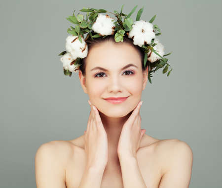 Smiling Woman with Healthy Skin and White Cotton Flowers. Skincare, Facial Treatment, Massage and Pampering Conceptの写真素材