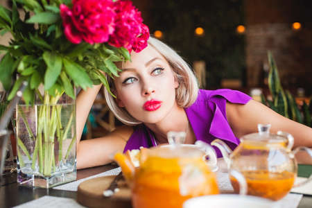 Blonde woman sitting in restaurantの写真素材