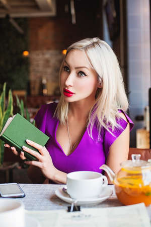 Pretty Woman with Book in Restaurantの写真素材