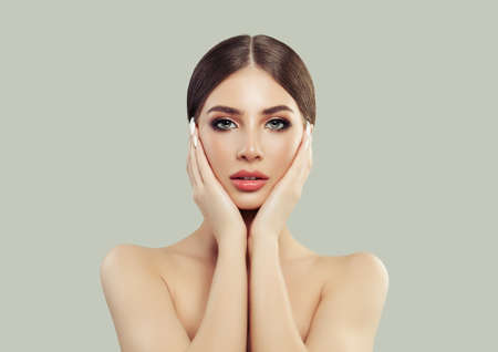 Beautiful Young Woman Holding her Face in her Hands. Plastic Surgery and Facial Treatment Conceptの写真素材