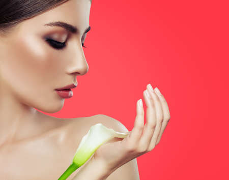 Closeup beauty portrait of beautiful woman with white flowerの写真素材
