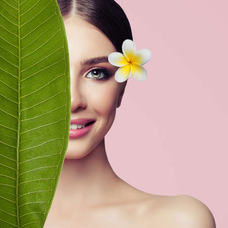 Beautiful female face closeup. Spa beauty, herbal treatment and skincare conceptの写真素材