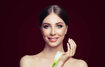 Smiling woman with healthy skin and white flower. Facial treatment, cosmetology and spa beautyの写真素材
