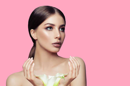 Spa model woman with healthy skin and manicured hands and white flower. Facial treatment, cosmetology and spa beautyの写真素材