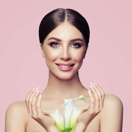 Nice woman with healthy skin, manicured hands and white flowers. Facial treatment, cosmetology and spaの写真素材