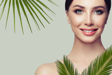 Natural Beauty Portrait. Beautiful Spa Woman with Green Leaves. Perfect Fresh Skinの写真素材