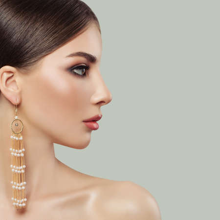 Beautiful woman face. Girl with fashion jewelry portrait. Perfect female profileの写真素材