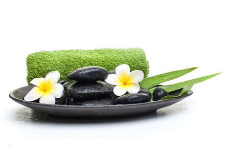 spa flower and black stones with green towel on dark plateの写真素材